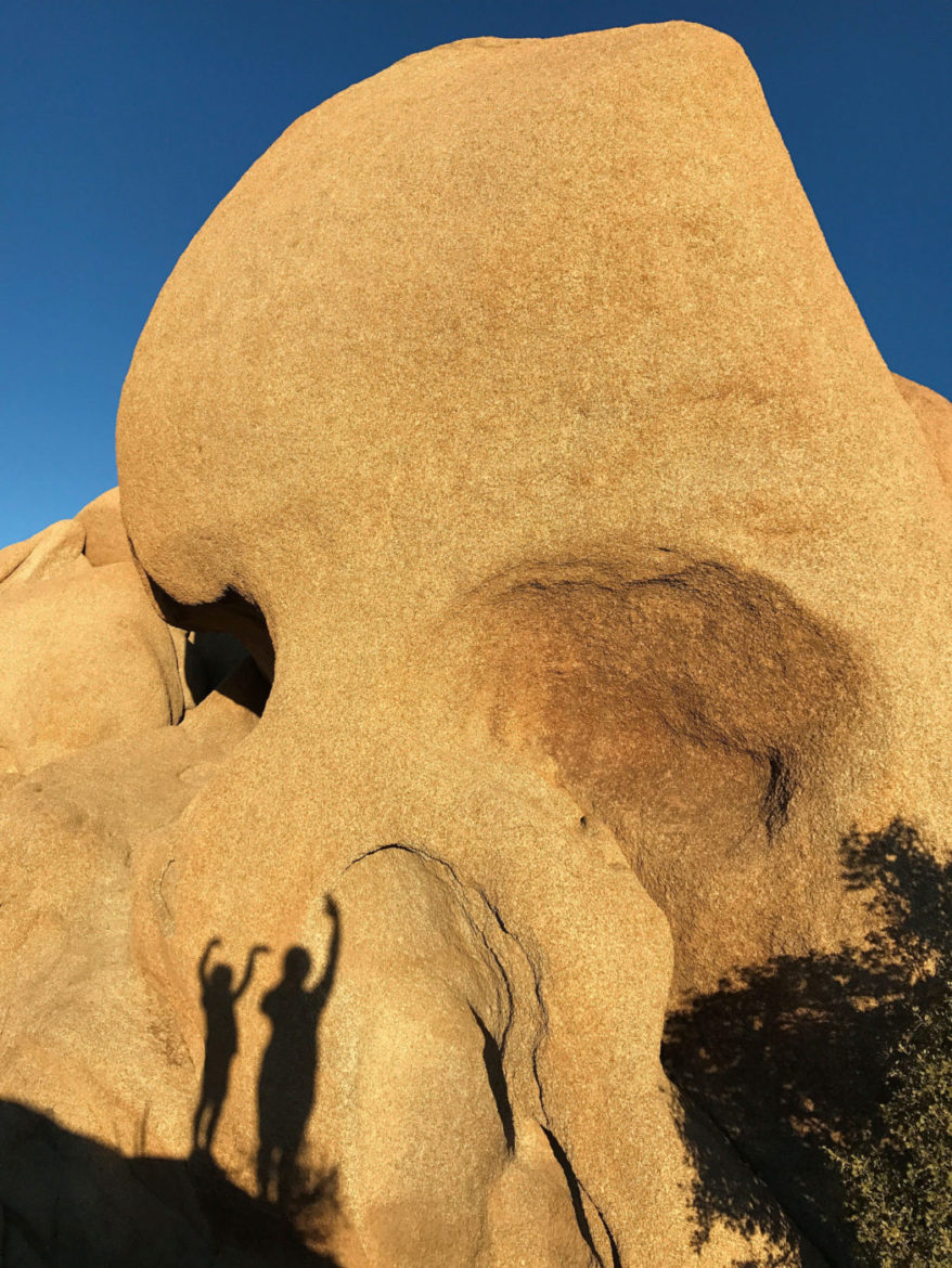 Playing with our shadows on Skull Rock in Joshua Tree National Park