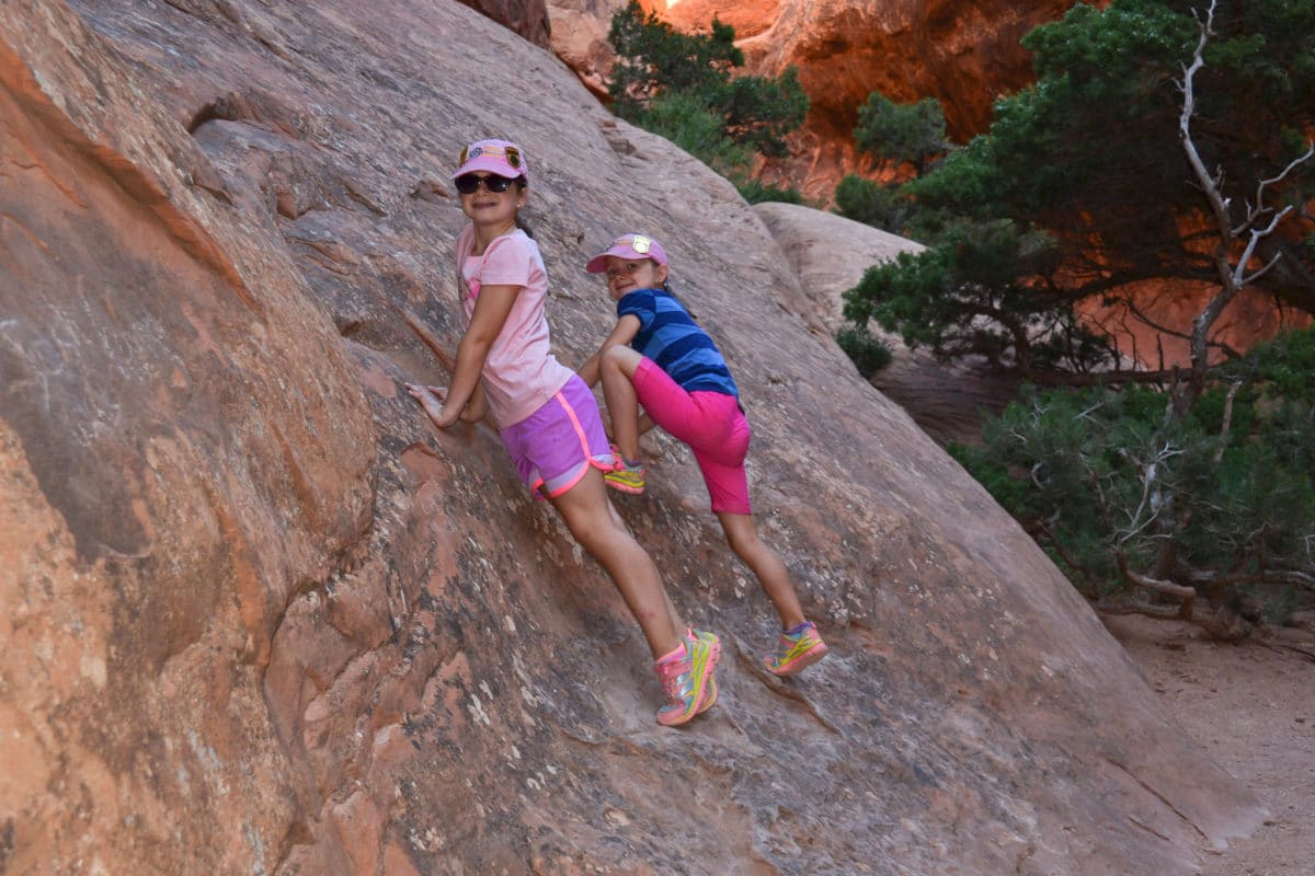 Kids climbing on rocks near Navajo Arch