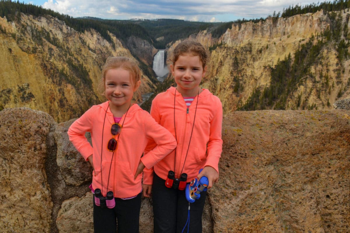 Kids standing at Artist Point with the Grand Canyon of the Yellowstone behind