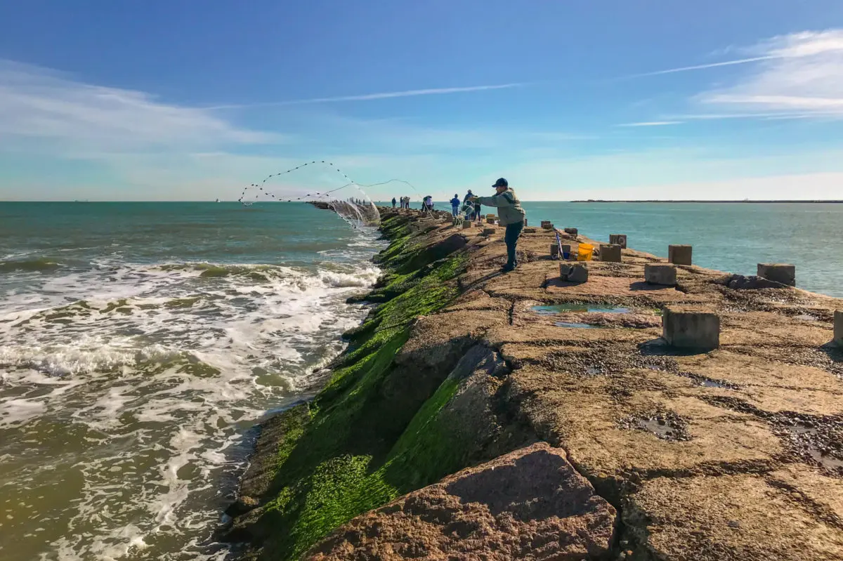 Throwing a fishing net from the jetties at Isla Blanca Park