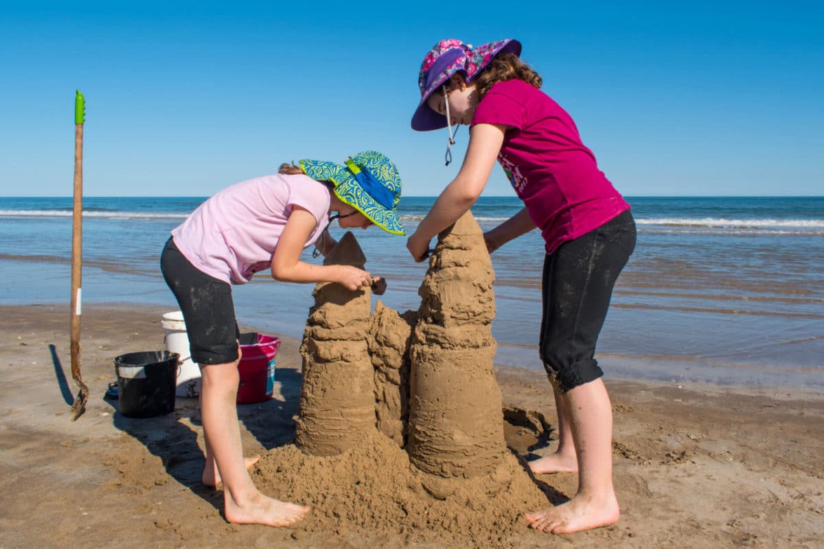 The kids shaping the sandcastle
