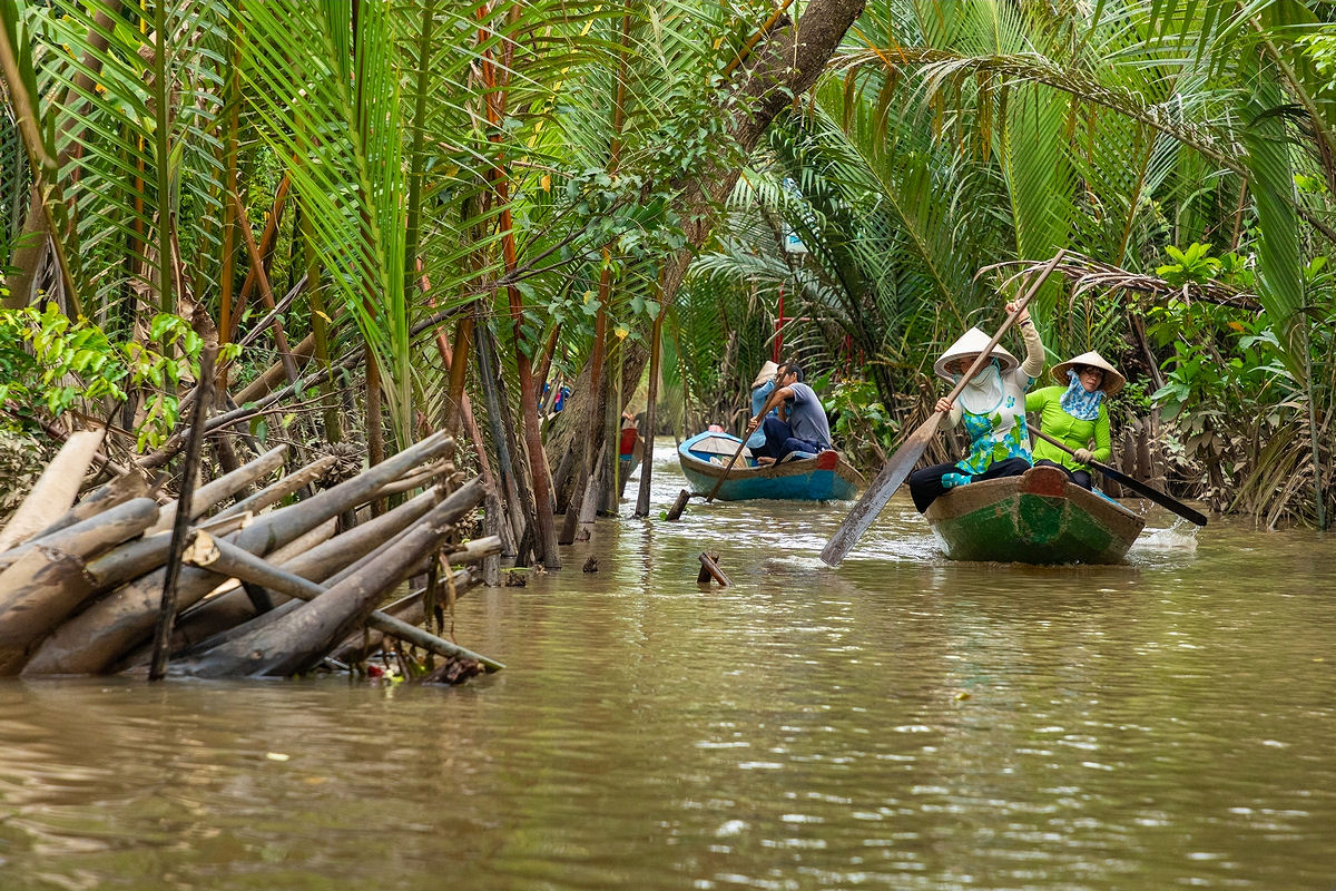 Locals rowing traditional boats on the Mekong Delta in South Vietnam