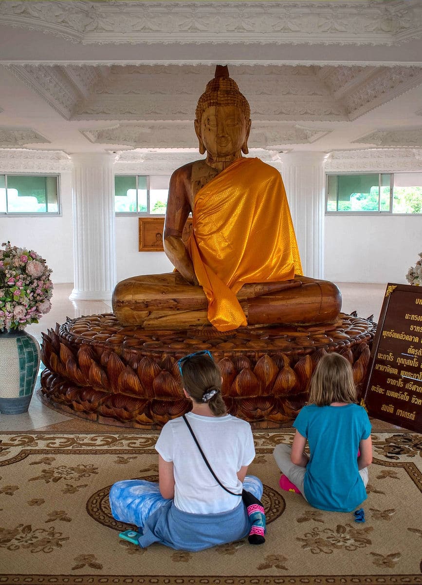 The kids in front of a wood Buddha statue at Wat Huay Pla Kang in Chiang Rai