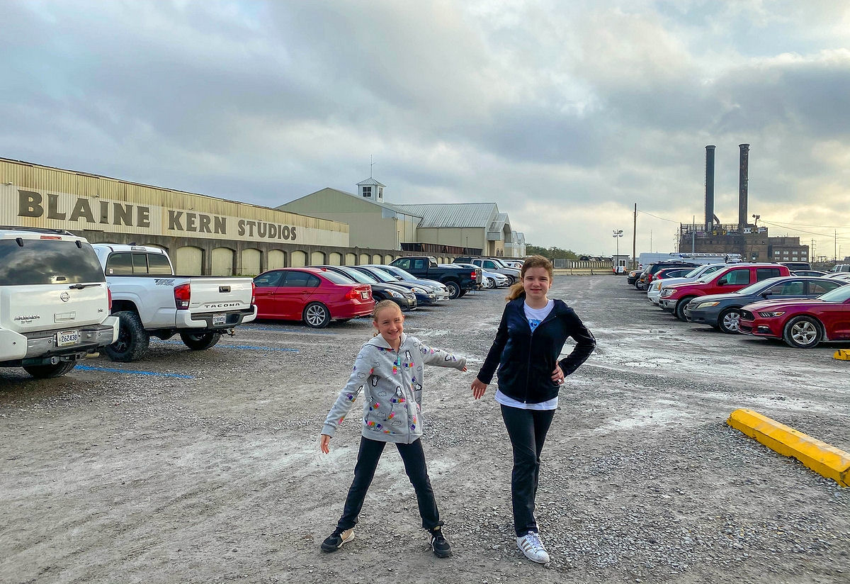 The kids in the parking lot of Mardi Gras World
