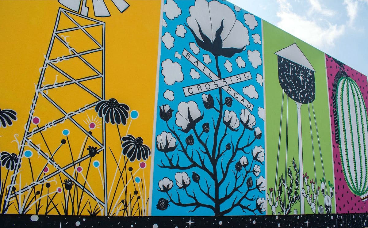 A wall with colorful murals in downtown Plano